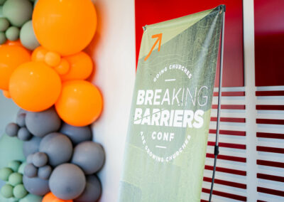 Breaking Barriers Signage with balloons in the background
